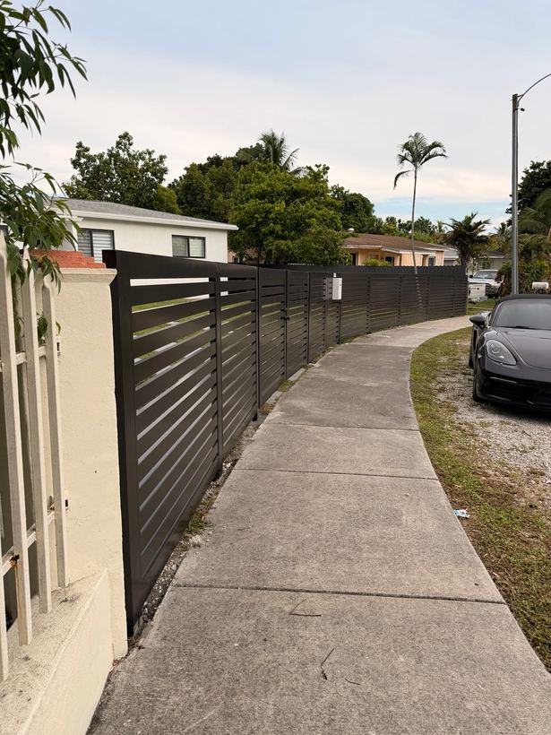 Bronze horizontal slat fence running along a side walkway