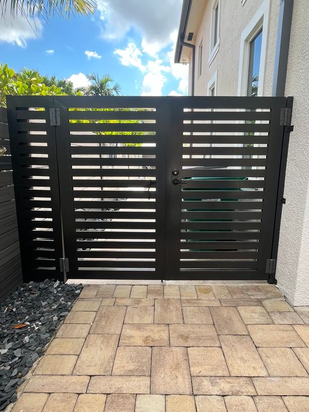 Black horizontal slat double gate on a paver walkway