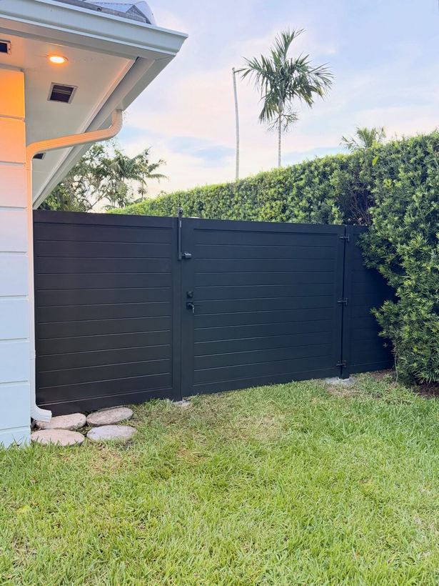 Black horizontal slat aluminum side gate with matching privacy fence