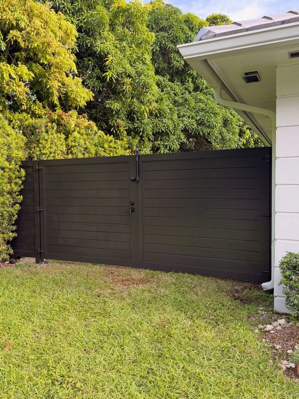 Black horizontal slat aluminum gate with privacy fence panel