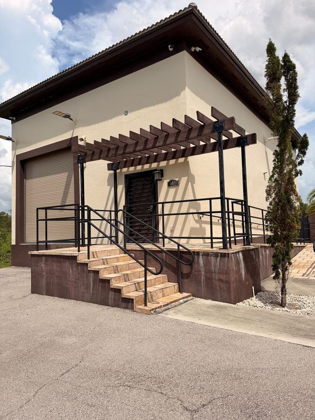 Steel stair railings and guardrails under a wood pergola at a commercial entry