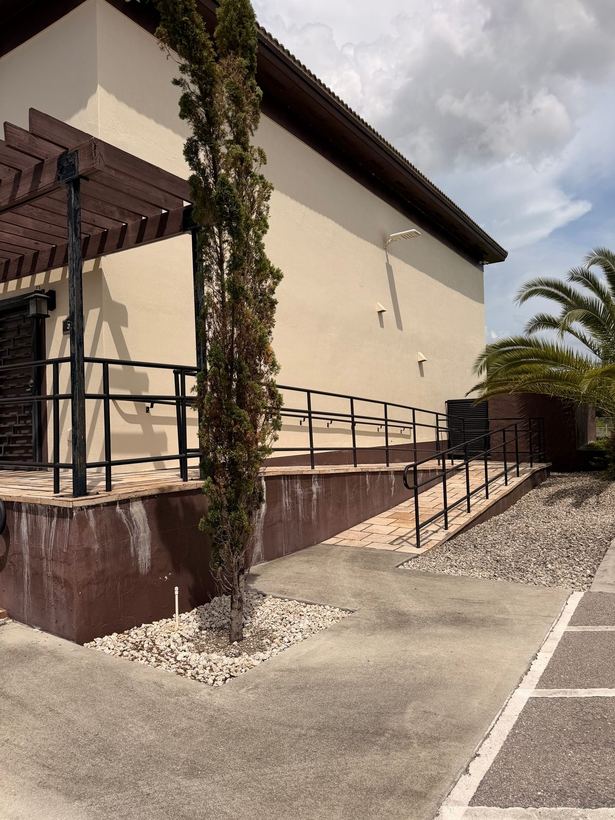 Long black ramp railing running along the side of a commercial building
