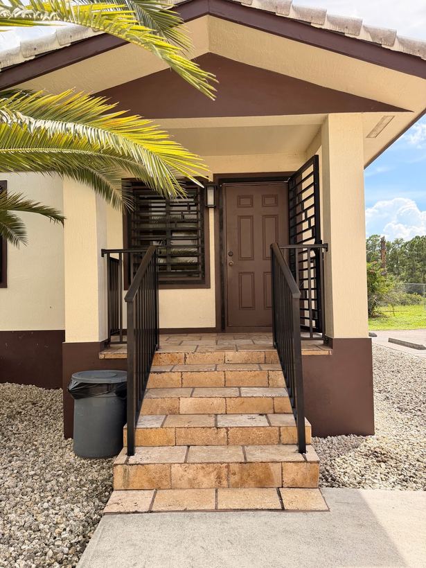 Residential porch steps with railings and slat screen panels