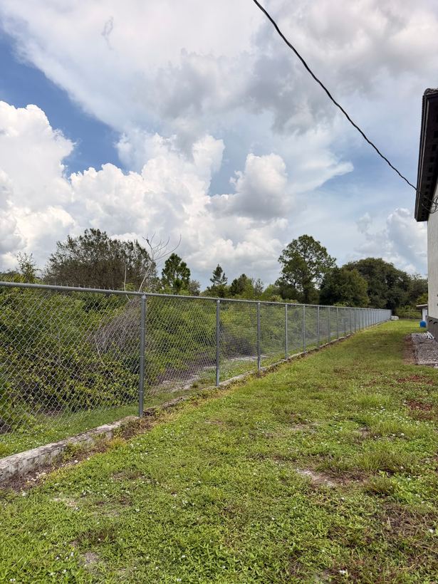 Galvanized chain link perimeter fence along a commercial property line